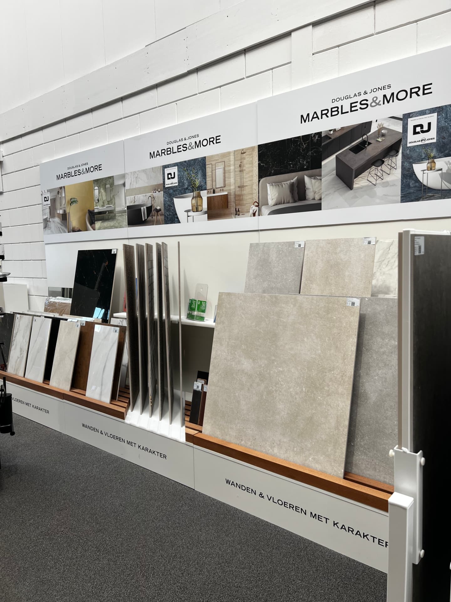 Presentatiewand met wand- en vloertegels in marmer- en natuursteenlook in onze showroom in Utrecht