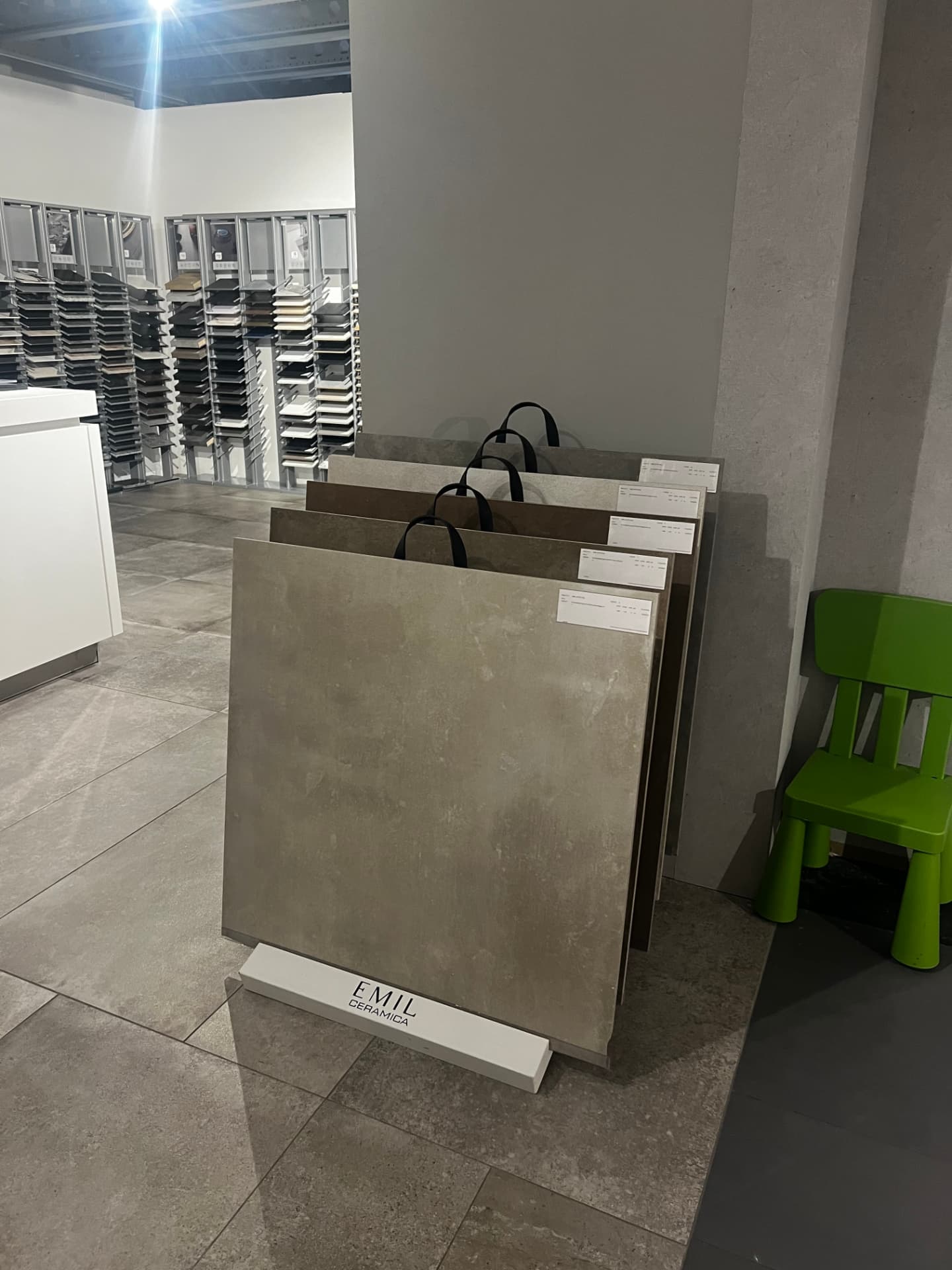 Tegeldisplay met grote vloertegels in grijze en aardse tinten in onze showroom in Utrecht